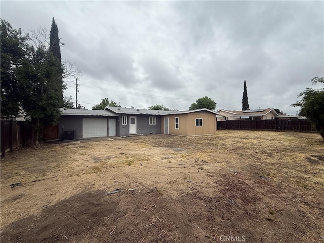 back of house featuring fence and an attached garage