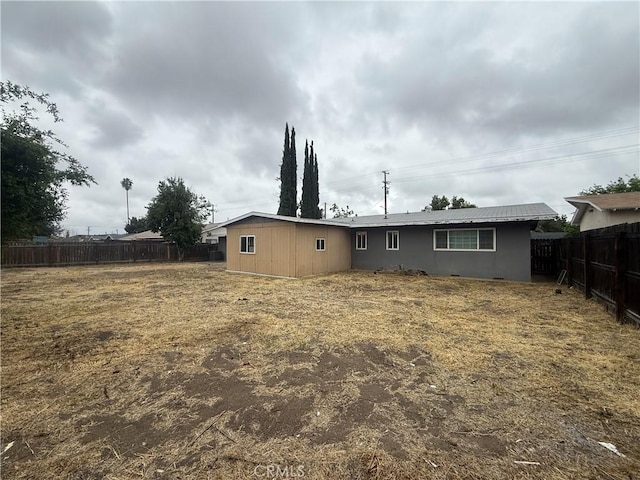 back of house featuring a fenced backyard and stucco siding