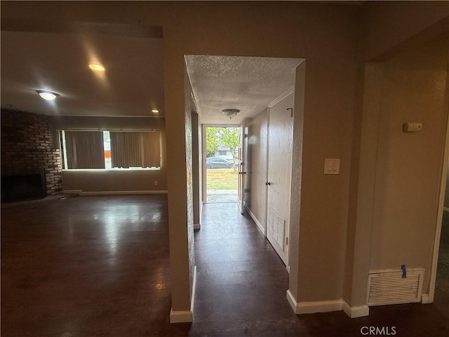 hallway featuring baseboards and a textured ceiling