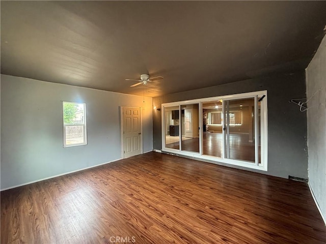 unfurnished room featuring wood finished floors, a ceiling fan, and baseboards