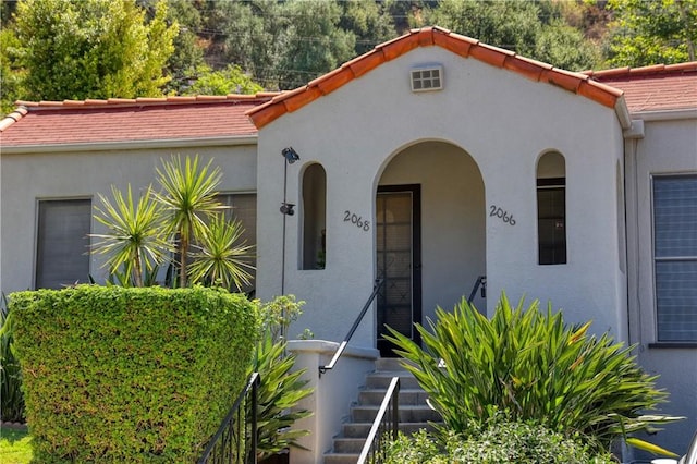 mediterranean / spanish-style house with stucco siding and a tile roof