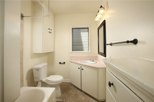 full bath with vanity, tile patterned flooring, toilet, and a tub to relax in