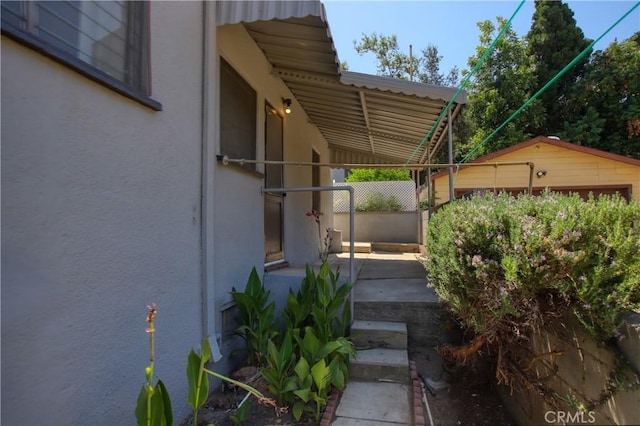 view of property exterior featuring stucco siding and fence
