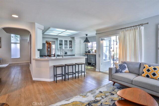 1398 Carissa St, Upland, CA 91784 - living room with wood finished floors, arched walkways, baseboards, and recessed lighting