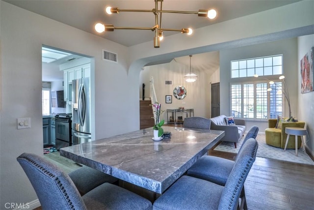 1398 Carissa St, Upland, CA 91784 - dining room featuring a chandelier, wood finished floors, arched walkways, and baseboards