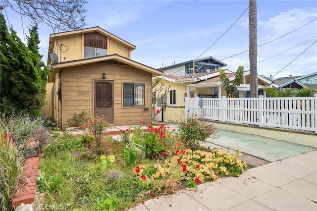 bungalow-style home with fence and stucco siding