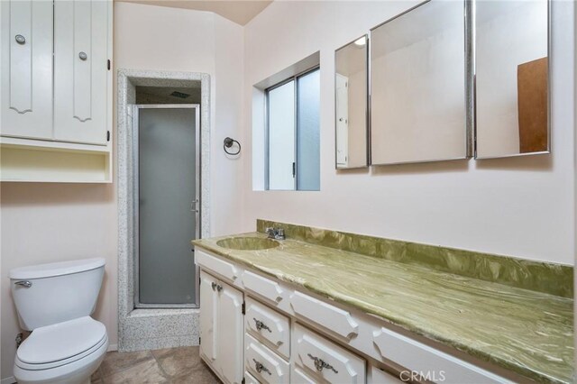 bathroom featuring a stall shower, vanity, and toilet