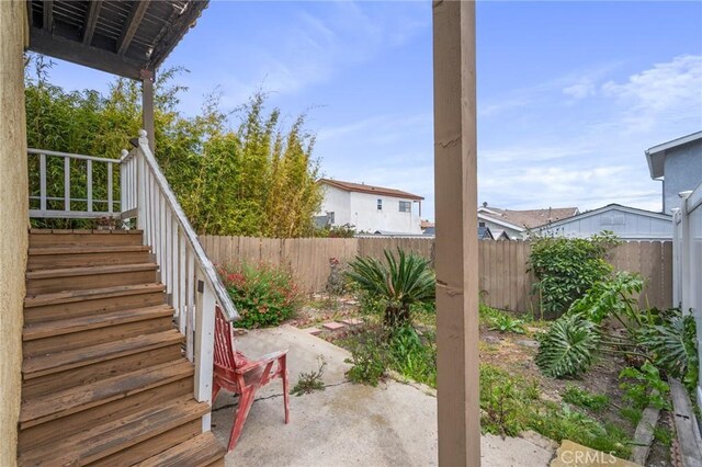 fenced backyard featuring a patio and stairs