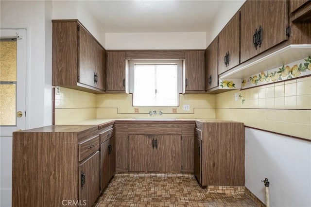 kitchen featuring a sink, decorative backsplash, and light countertops