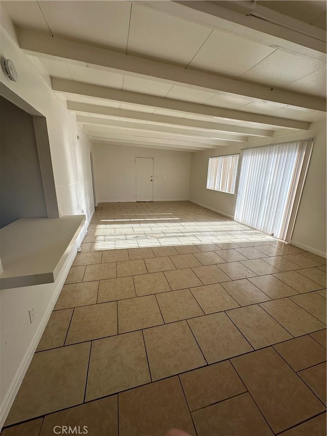 44226 2nd St E, Lancaster, CA 93535 - unfurnished room with beamed ceiling, light tile patterned floors, and baseboards