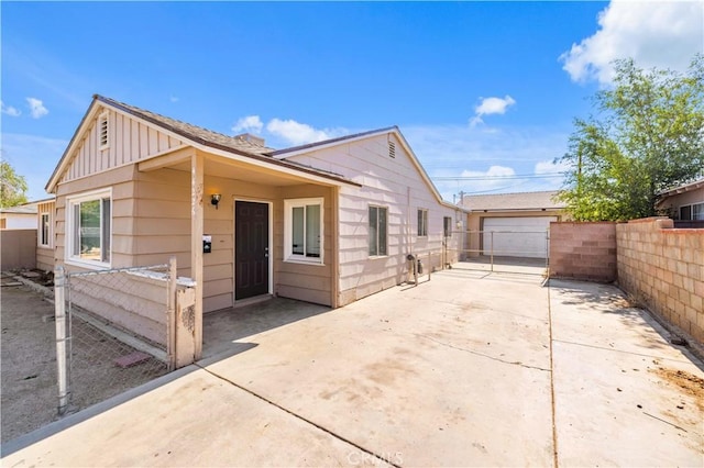44226 2nd St E, Lancaster, CA 93535 - view of front of home with board and batten siding, a detached garage, and a patio