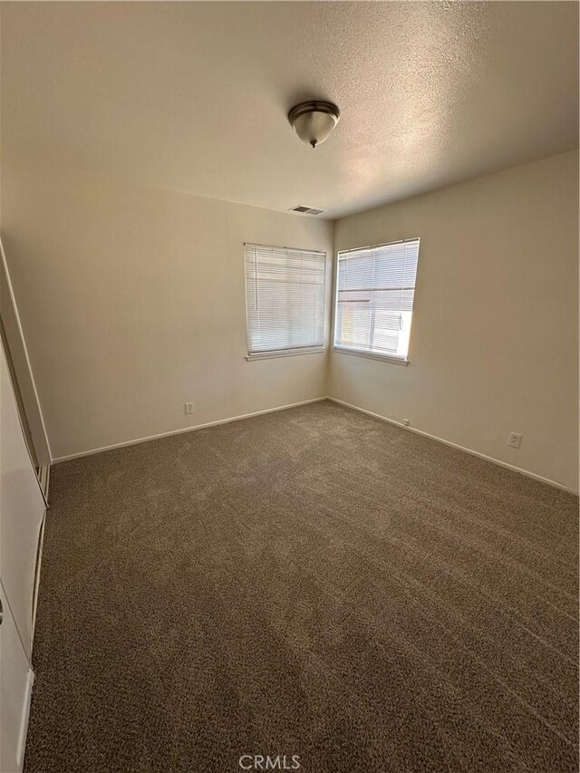 44226 2nd St E, Lancaster, CA 93535 - spare room featuring dark carpet, baseboards, and a textured ceiling