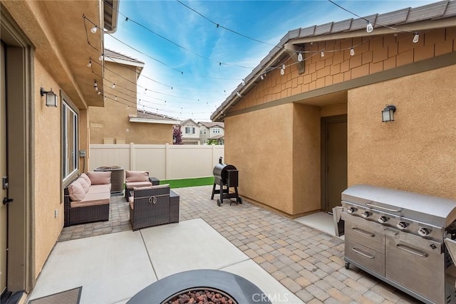 view of patio featuring fence, outdoor lounge area, and a grill