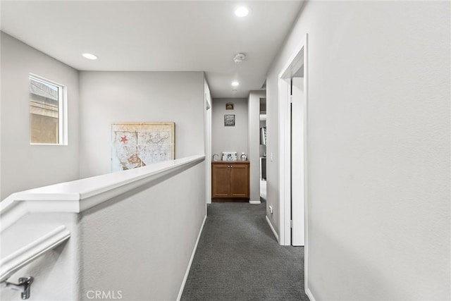 hall with dark colored carpet, recessed lighting, and baseboards