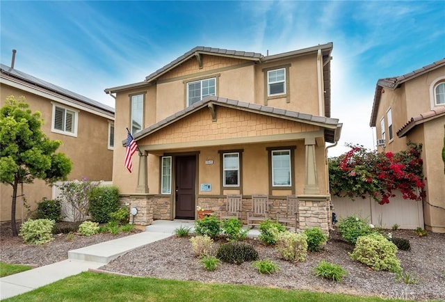 craftsman house with covered porch, stone siding, and stucco siding