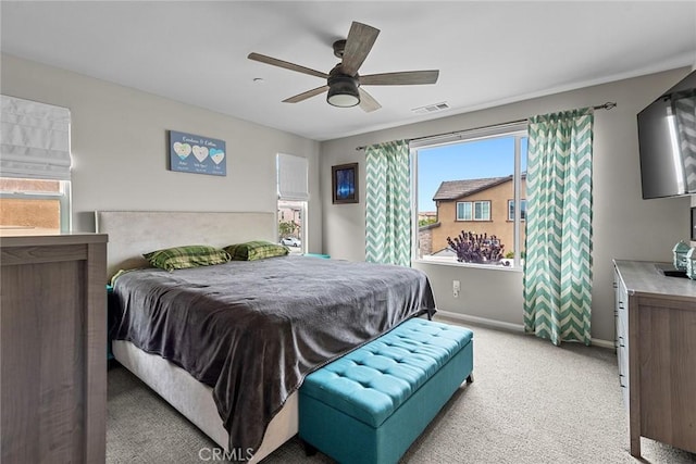 bedroom with light carpet, baseboards, and a ceiling fan