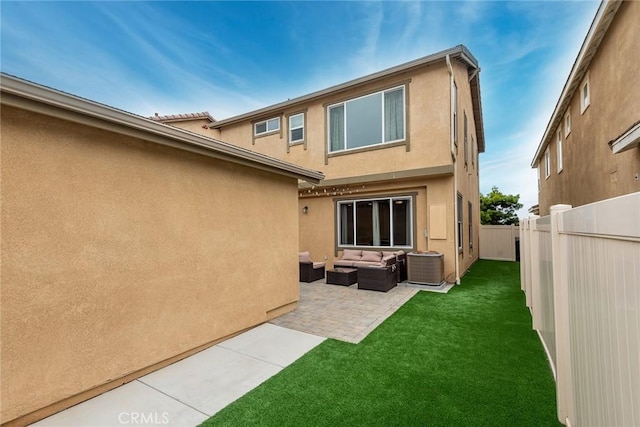 back of house with outdoor lounge area, central air condition unit, a patio area, and stucco siding