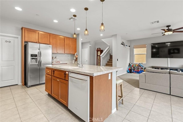 kitchen with stainless steel fridge, a sink, open floor plan, ceiling fan, and light tile patterned floors