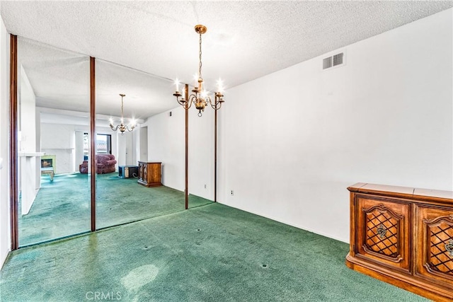 16512 Blackbeard Ln Unit 102, Huntington Beach, CA 92649 - unfurnished dining area with a chandelier, carpet flooring, and a textured ceiling