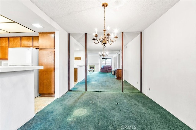 16512 Blackbeard Ln Unit 102, Huntington Beach, CA 92649 - unfurnished dining area with light colored carpet, a chandelier, and a textured ceiling