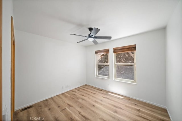 empty room featuring light wood finished floors, ceiling fan, and baseboards