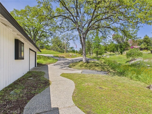 43642 Crystal Cave Cir, Coarsegold, CA 93614 - view of green lawn featuring a garage and driveway