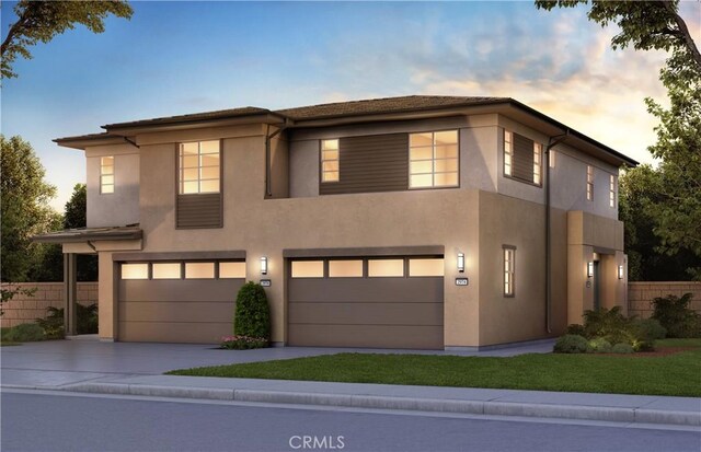 view of front of property featuring an attached garage, fence, concrete driveway, and stucco siding