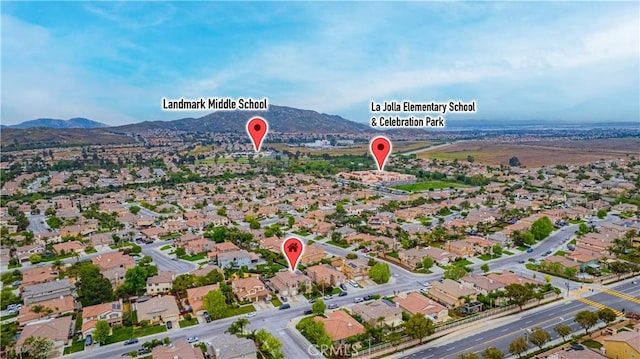 aerial view of property and surrounding area with a mountainous background and nearby suburban area