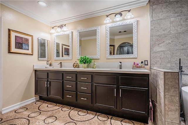 bathroom with crown molding, double vanity, and baseboards