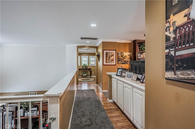 hall with crown molding, wood finished floors, and recessed lighting