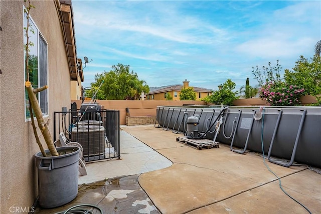 view of patio featuring a fenced backyard, an outdoor pool, and cooling unit