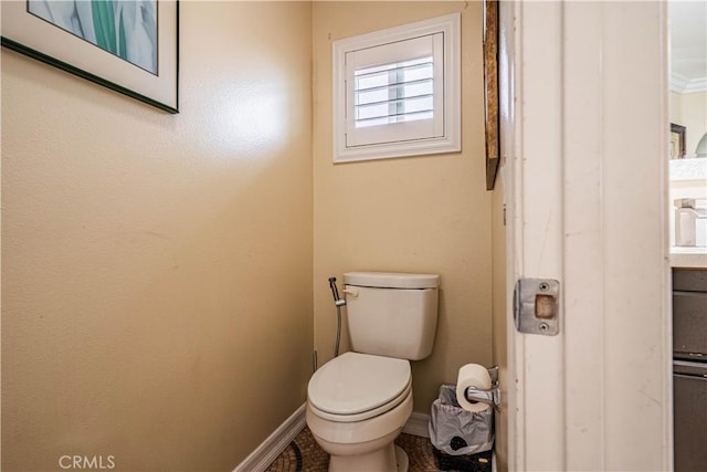 bathroom with toilet, baseboards, and vanity