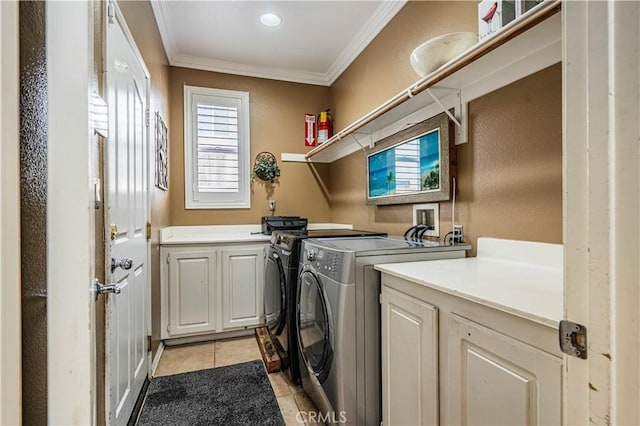 washroom featuring cabinet space, washing machine and dryer, light tile patterned flooring, and ornamental molding
