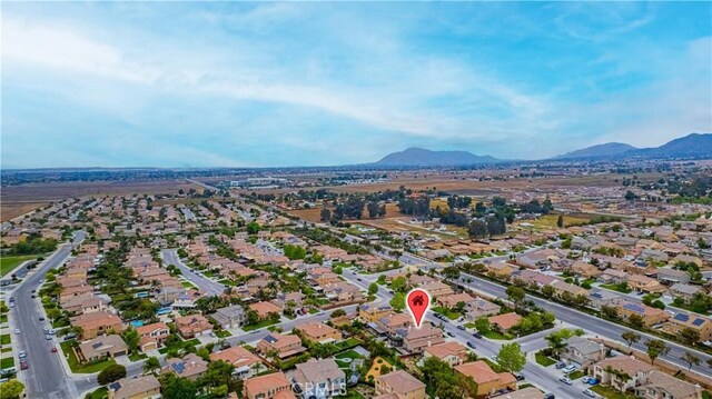 aerial view of property's location with a mountainous background and nearby suburban area