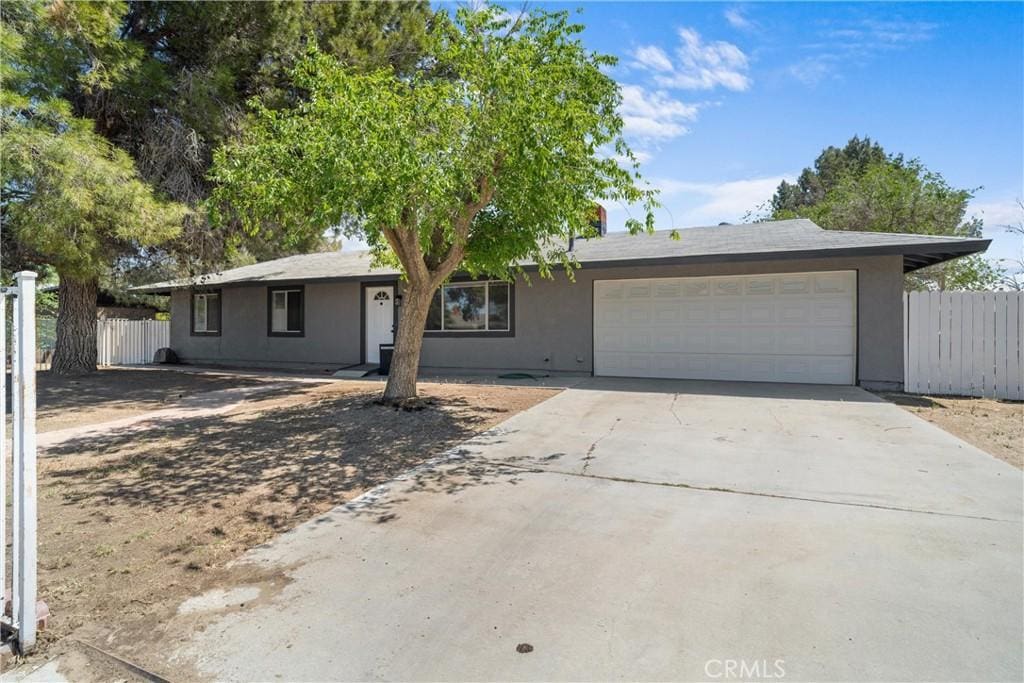 40586 166th St E, Lancaster, CA 93535 - ranch-style house featuring fence, an attached garage, concrete driveway, and stucco siding