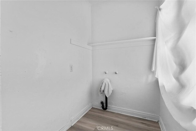 laundry room featuring wood finished floors and baseboards