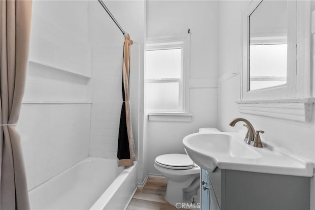 bathroom featuring vanity, toilet, wood finished floors, and shower / tub combo with curtain
