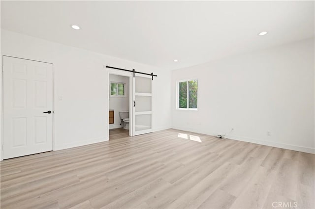 5826 Jamieson Ave, Encino, CA 91316 - unfurnished bedroom featuring a barn door, light wood-type flooring, baseboards, and recessed lighting