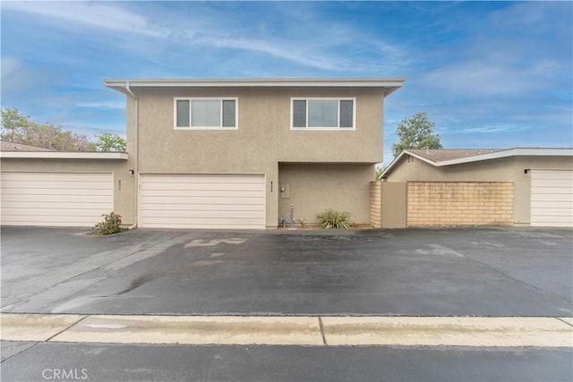 view of front facade featuring stucco siding, asphalt driveway, and an attached garage