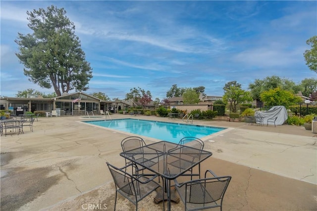 community pool featuring a patio area and fence