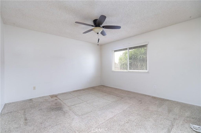 carpeted empty room with a textured ceiling and a ceiling fan