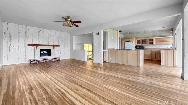 2001 Kenilworth Ave, Los Angeles, CA 90039 - unfurnished living room featuring light wood finished floors, a ceiling fan, wallpapered walls, a brick fireplace, and baseboards