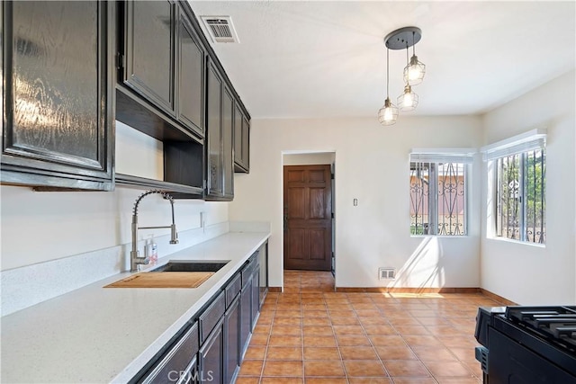 6255 Satsuma Ave, North Hollywood, CA 91606 - kitchen featuring a sink, light countertops, light tile patterned flooring, black range with gas cooktop, and decorative light fixtures