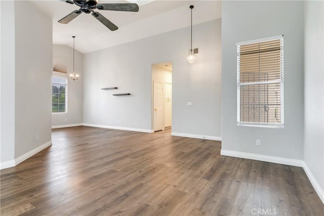 empty room with ceiling fan, baseboards, dark wood-type flooring, and high vaulted ceiling