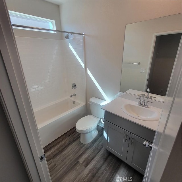 full bathroom featuring wood finished floors, toilet, vanity, and shower / bathtub combination