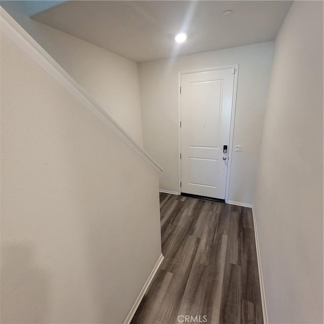 corridor with dark wood-style flooring, baseboards, and recessed lighting
