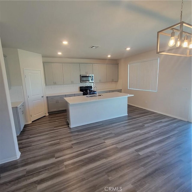 kitchen with stainless steel microwave, baseboards, dark wood-style flooring, light countertops, and recessed lighting
