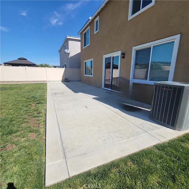rear view of property with central air condition unit, stucco siding, and a patio