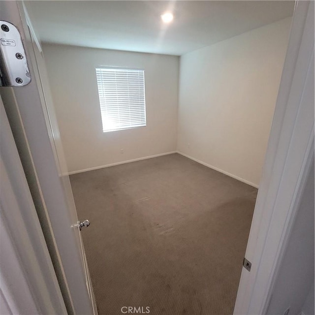 carpeted empty room with baseboards