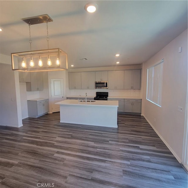 29145 Dune Primrose, Lake Elsinore, CA 92530 - kitchen with stainless steel microwave, black stove, a center island with sink, recessed lighting, and dark wood-type flooring